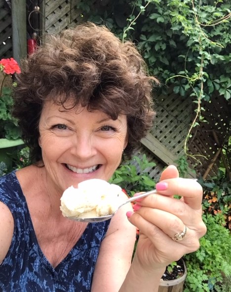 mairlyn is holding a spoonful of homemade vanilla ice cream