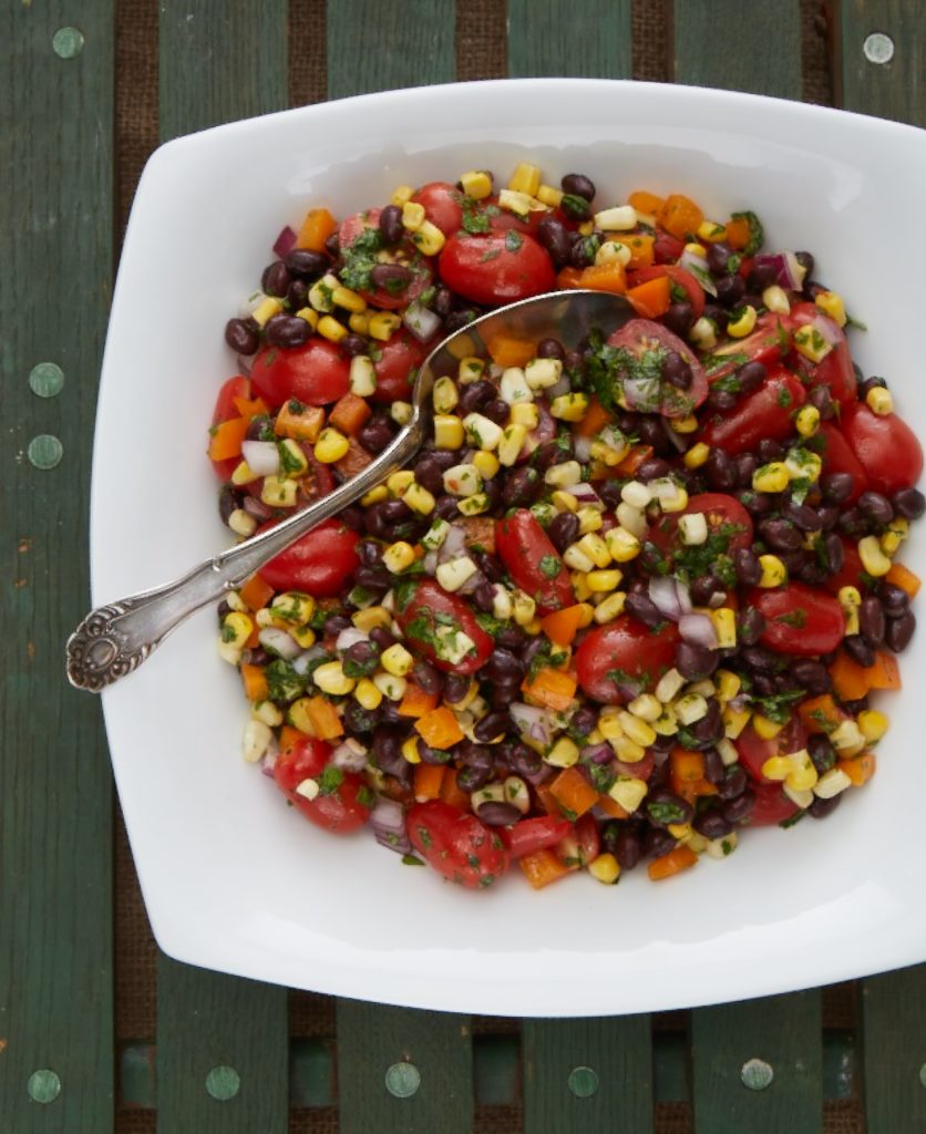 a black bean salad with peppers, onion, grilled corn and cherry tomatoes